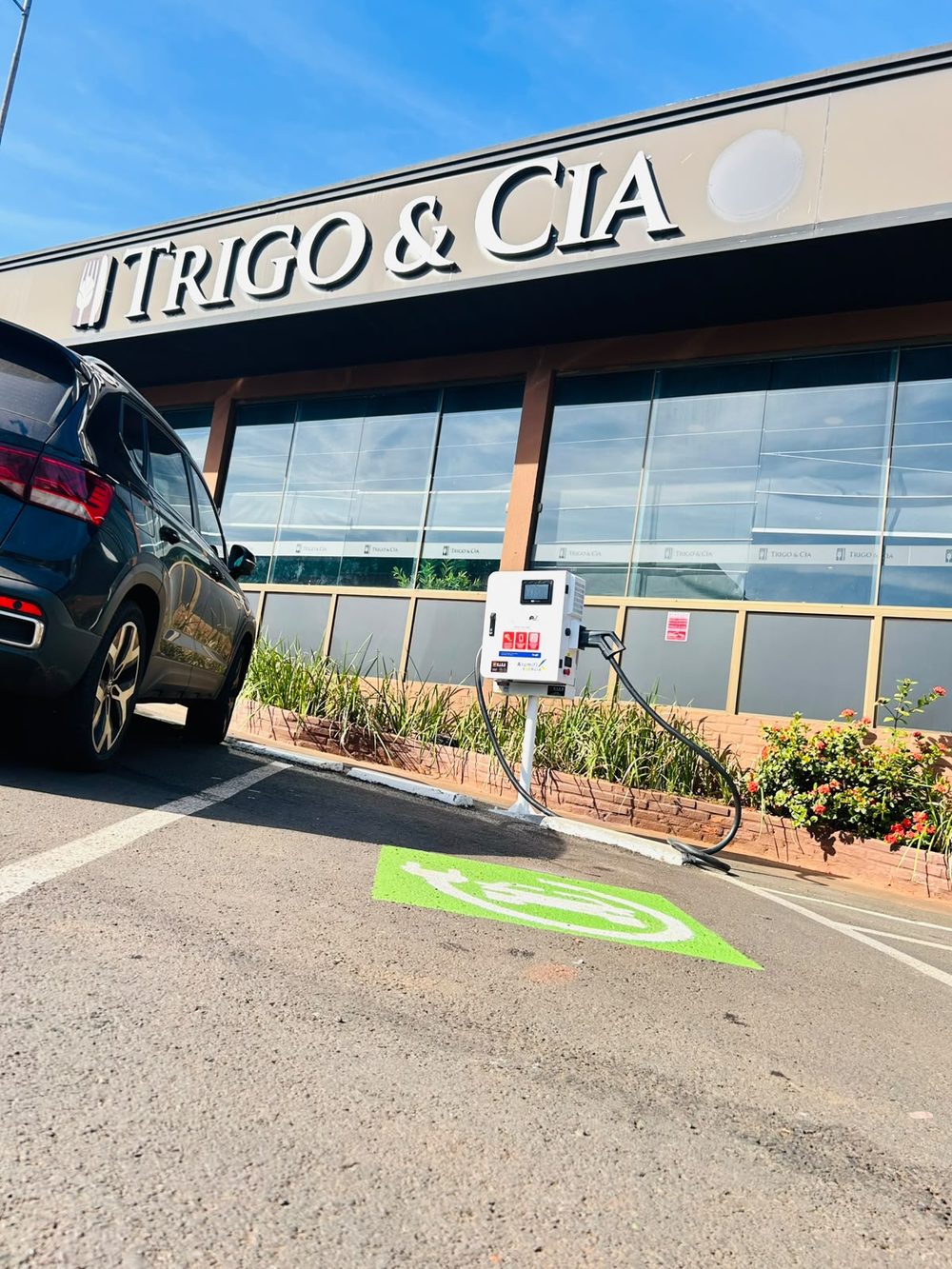 Vaga de recarga demarcada e pintada, com o carregador instalado no pátio da Trigo e Cia
