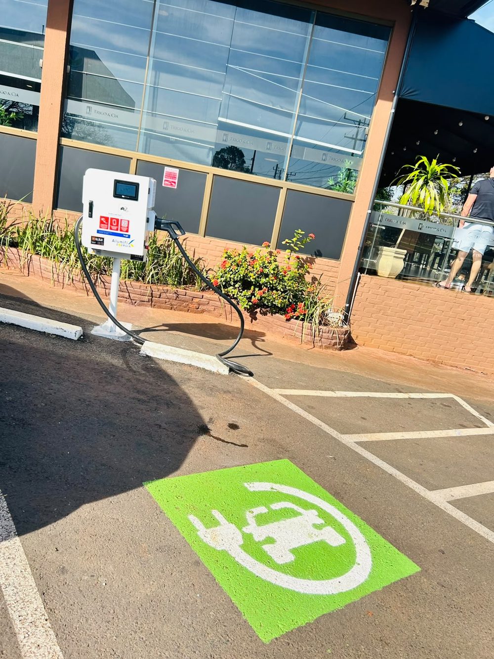 Carregador instalado no pátio da panificadora Trigo e Cia, com movimento de clientes na entrada
